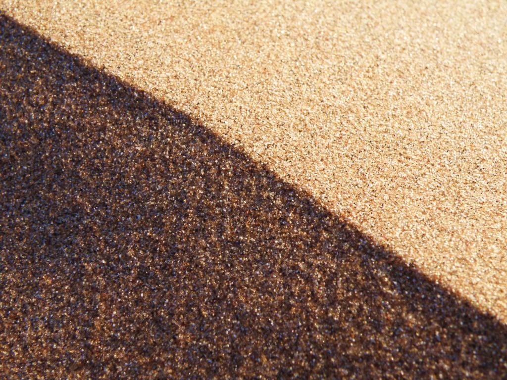 Světlo a stín. Zrnka na hraně písečné duny 